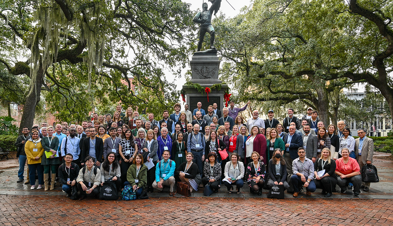 A group of NSNC 2022 attendees stand by a statue.